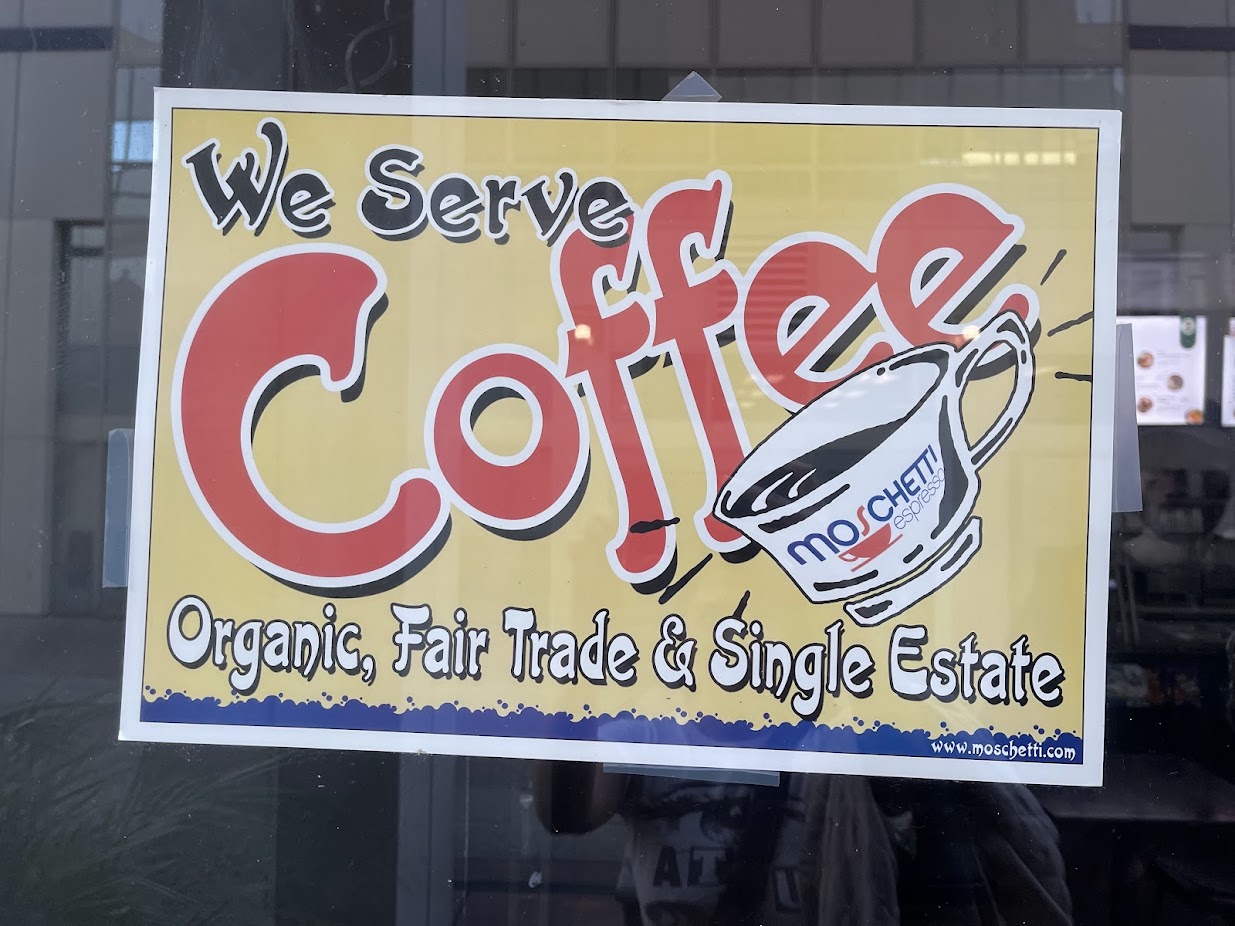 a sign in a window that says 'We serve coffee